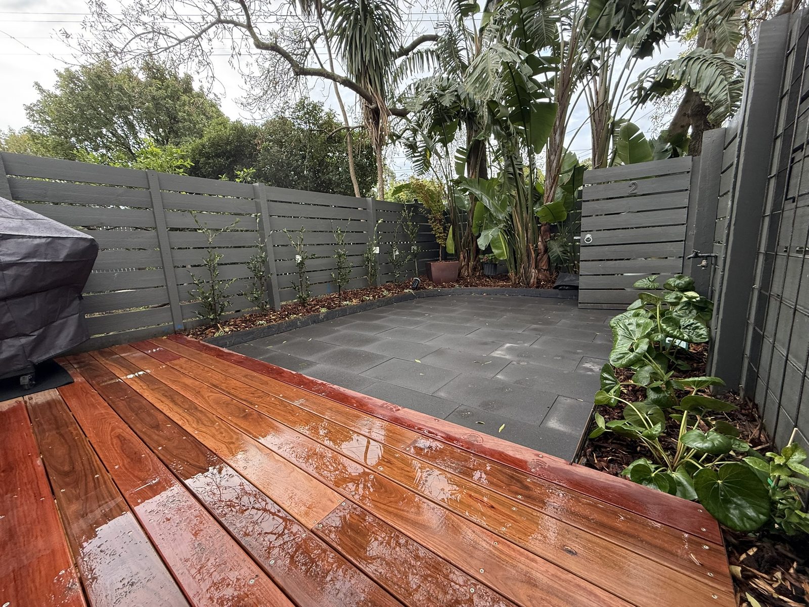 Kew courtyard — Ironbark deck, charcoal paving and layered planting